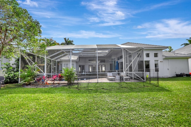 rear view of house featuring glass enclosure, a patio area, and a yard