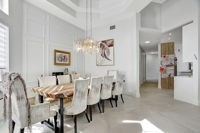 dining room with a high ceiling and an inviting chandelier