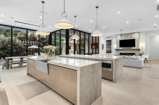 kitchen with expansive windows, a spacious island, and hanging light fixtures