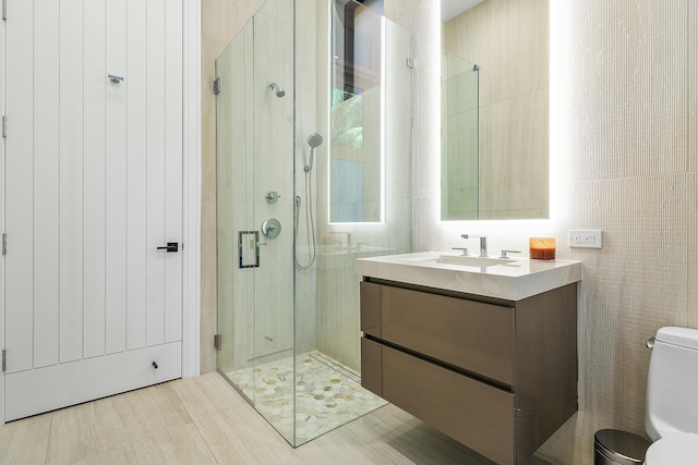 bathroom with tile patterned flooring, vanity, toilet, and a shower with shower door