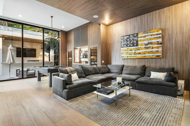 playroom with indoor bar, a towering ceiling, wooden walls, and pool table