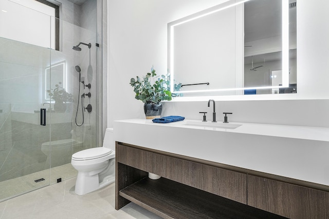 bathroom with tile patterned floors, vanity, toilet, and a shower with shower door