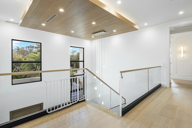 hall with light hardwood / wood-style flooring and wooden ceiling