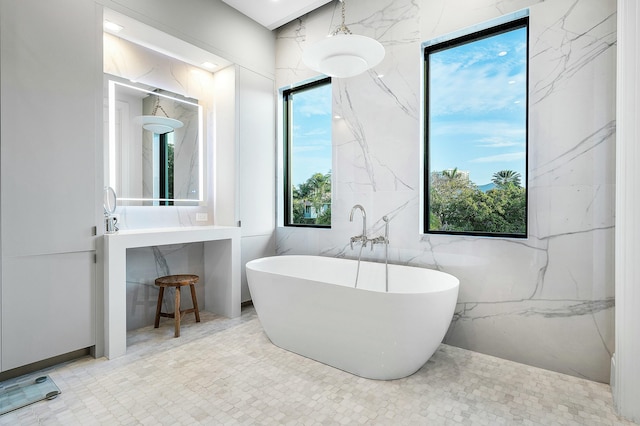 bathroom featuring a bathtub, tile walls, and a wealth of natural light