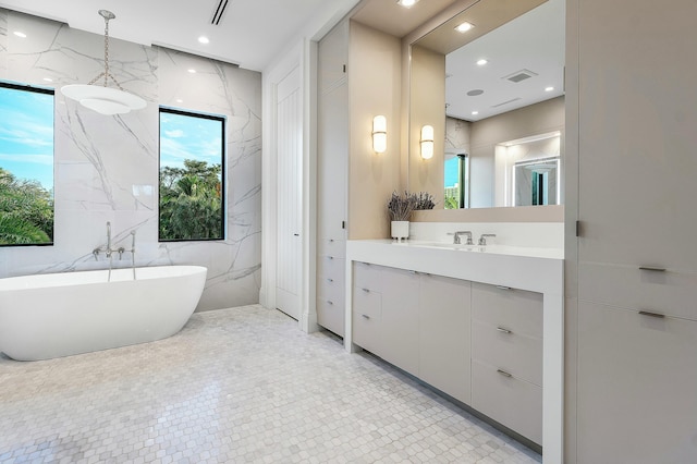 bathroom with vanity, tile patterned floors, tile walls, and a bathing tub