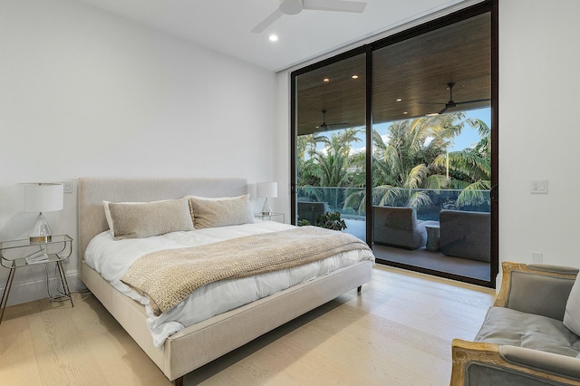 bedroom featuring ceiling fan, access to exterior, a wall of windows, and light hardwood / wood-style flooring