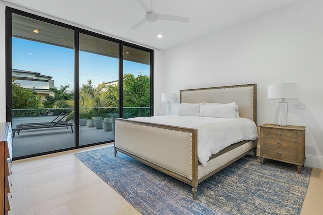 bedroom with access to outside, hardwood / wood-style flooring, a wall of windows, and ceiling fan