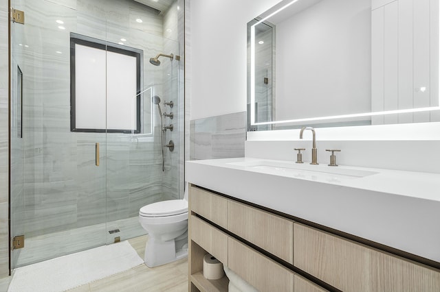 bathroom with vanity, toilet, and an enclosed shower