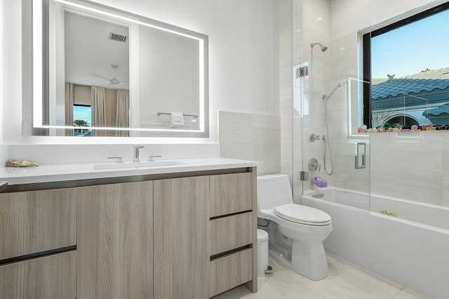 full bathroom featuring tile patterned flooring, toilet, vanity, and combined bath / shower with glass door