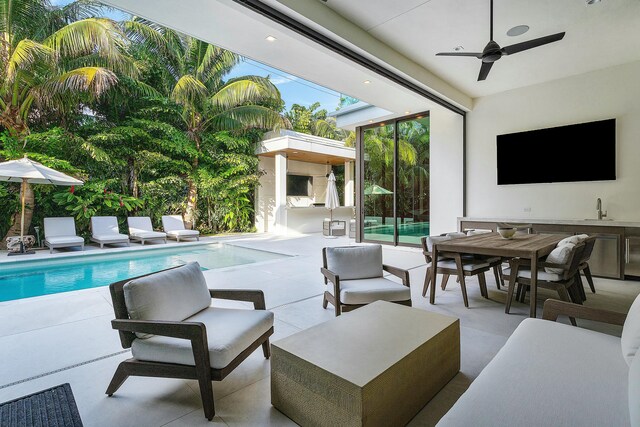 view of swimming pool with outdoor lounge area, ceiling fan, and a patio