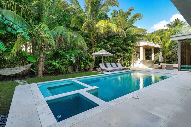 view of pool with an in ground hot tub and a patio