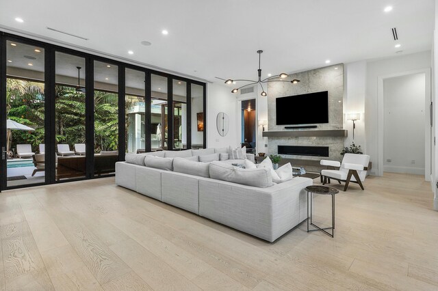 living room featuring an inviting chandelier, sink, and light hardwood / wood-style flooring