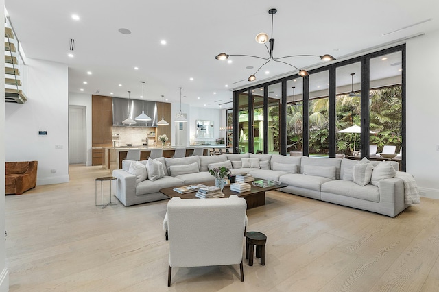 living room featuring plenty of natural light, light hardwood / wood-style floors, and floor to ceiling windows