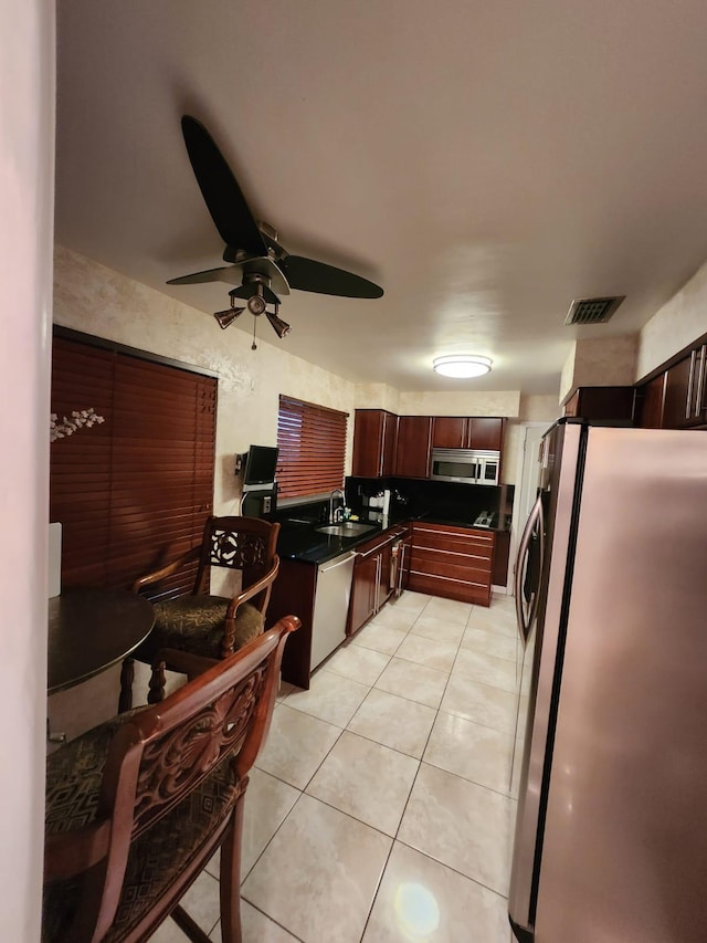 kitchen featuring ceiling fan, light tile patterned floors, sink, and appliances with stainless steel finishes