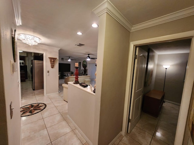 hallway with crown molding and light tile patterned floors