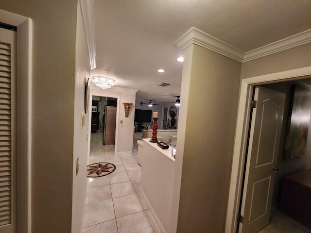 hallway featuring crown molding and light tile patterned flooring