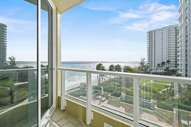 balcony with a water view and a view of the beach