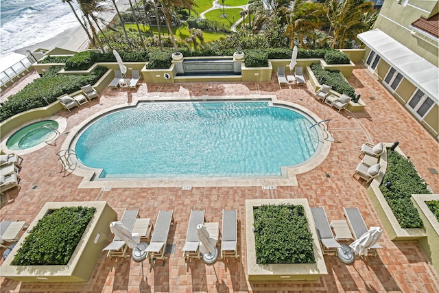 view of pool with a hot tub