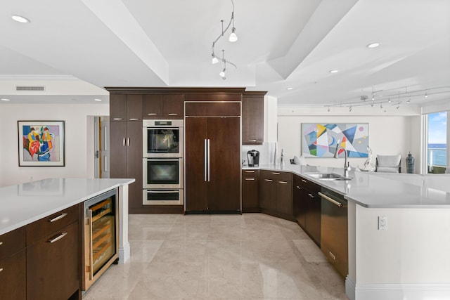 kitchen featuring paneled fridge, double oven, beverage cooler, sink, and dishwasher