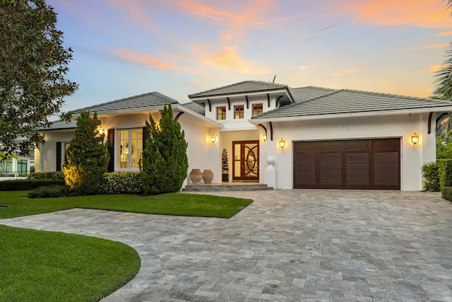 prairie-style home with a yard and a garage