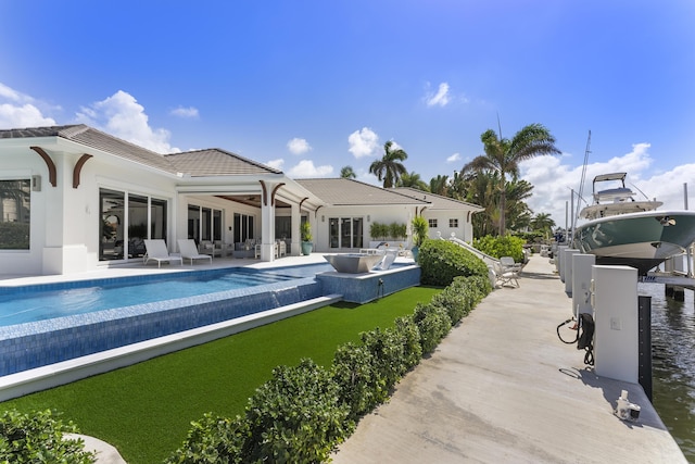 back of property with a patio area and a water view