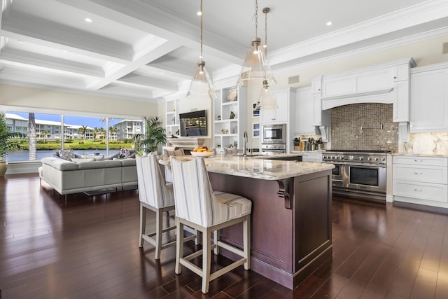 kitchen featuring light stone countertops, double oven range, beamed ceiling, white cabinets, and hanging light fixtures