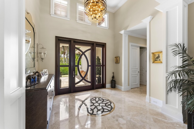 foyer featuring ornamental molding and an inviting chandelier