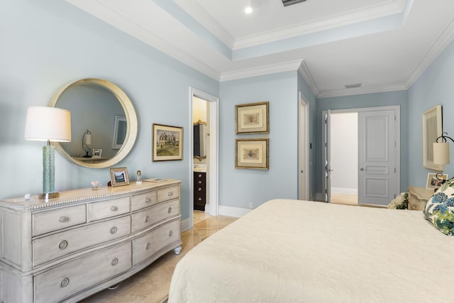 bedroom featuring a raised ceiling, ensuite bath, and ornamental molding