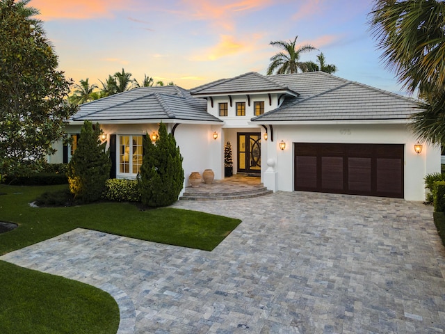 prairie-style home with a lawn and a garage