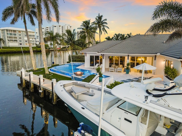 dock area with a water view and a patio