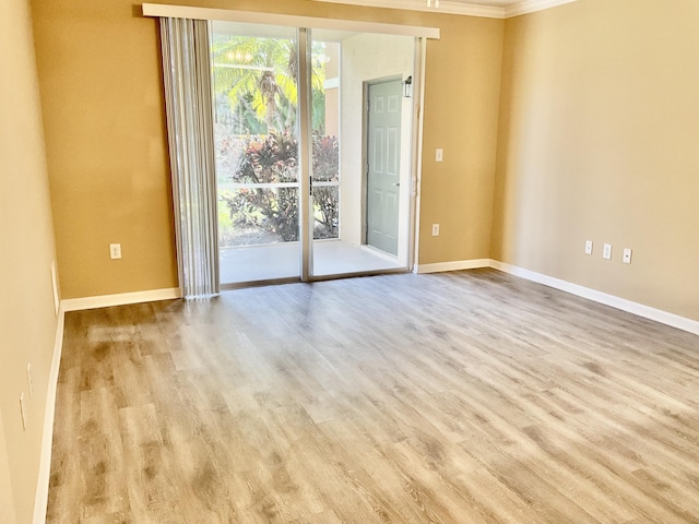 empty room with ornamental molding and light hardwood / wood-style flooring