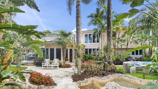 rear view of house featuring an outdoor hangout area, a patio area, and stucco siding