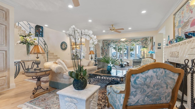 living room with ceiling fan, wood finished floors, stairs, crown molding, and recessed lighting