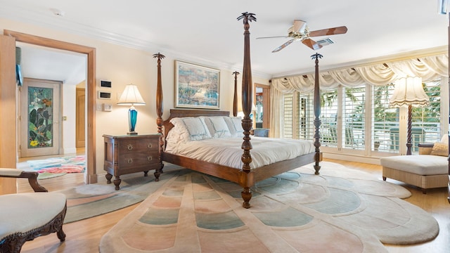 bedroom with ornamental molding, wood finished floors, and visible vents