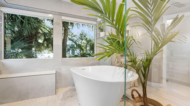 bathroom featuring tile patterned floors, toilet, and tile walls