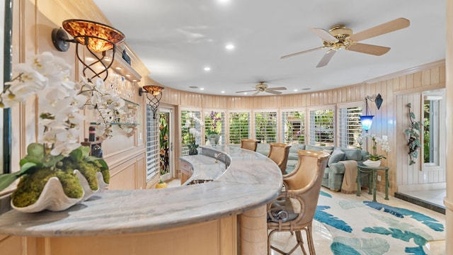 kitchen featuring wood walls, light stone counters, open floor plan, and recessed lighting