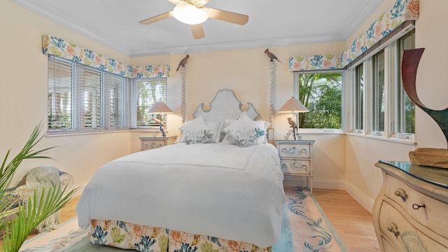 bedroom with baseboards, multiple windows, light wood-style flooring, and crown molding