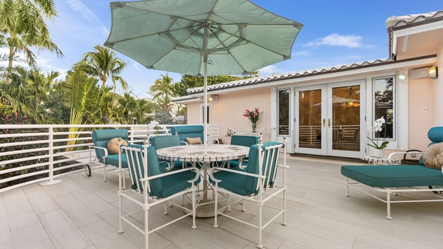 wooden terrace with french doors, an outdoor kitchen, and area for grilling