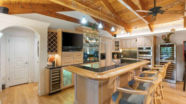 kitchen featuring stainless steel double oven, beverage cooler, light wood-style flooring, and lofted ceiling with beams