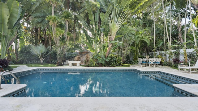 outdoor pool with a patio area and fence