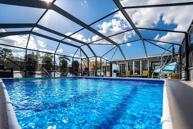 view of swimming pool featuring glass enclosure