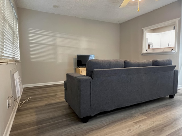 living room with hardwood / wood-style floors, ceiling fan, and a textured ceiling