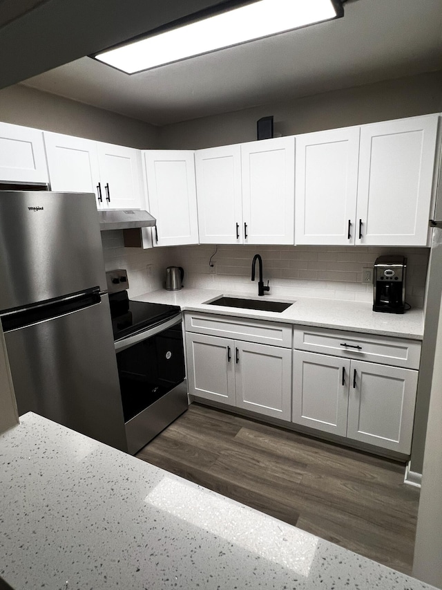 kitchen with sink, dark hardwood / wood-style flooring, backsplash, white cabinets, and appliances with stainless steel finishes