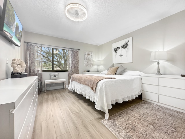 bedroom featuring light hardwood / wood-style flooring and a textured ceiling