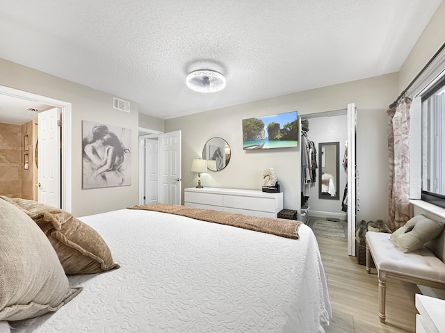 bedroom featuring light hardwood / wood-style flooring and a textured ceiling