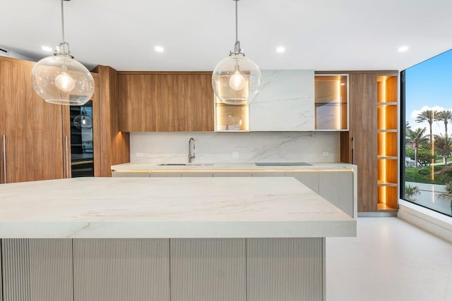 kitchen featuring sink, backsplash, pendant lighting, and expansive windows