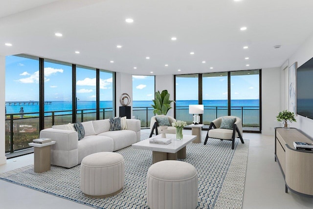 living room featuring a water view and a wall of windows