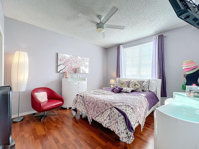 bedroom with hardwood / wood-style floors, ceiling fan, and a textured ceiling