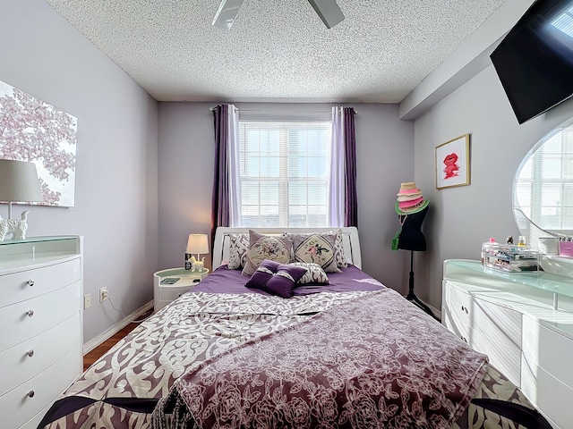 bedroom featuring hardwood / wood-style floors, a textured ceiling, and ceiling fan