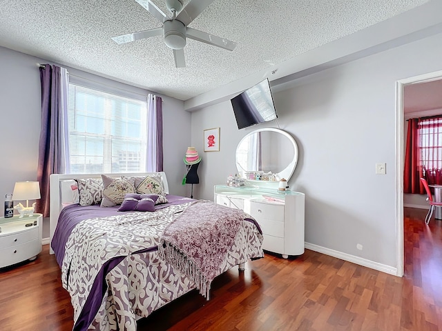 bedroom with a textured ceiling, ceiling fan, and dark hardwood / wood-style floors